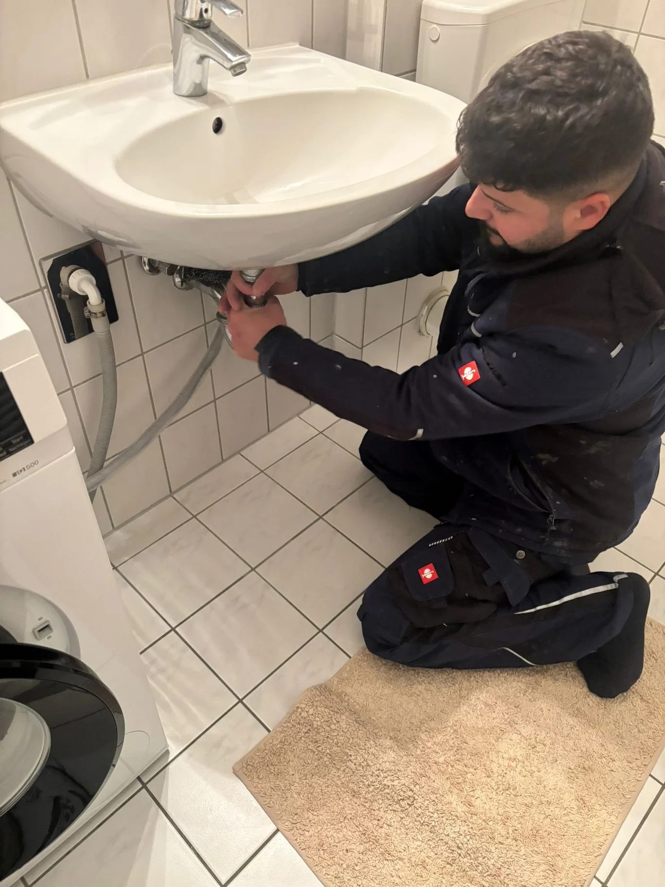 Sipan Mala Ali bei Sanitärarbeiten unter einem Waschbecken